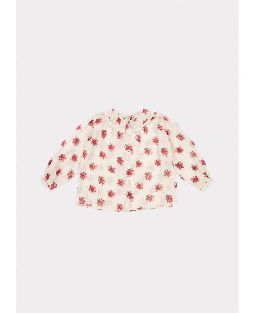camisa padrão floral rosa \ encarnado em fundo bege, volumosa com um colarinho plissado largo, mangas compridas com renda nos punhos, pregas na frente e nas costas