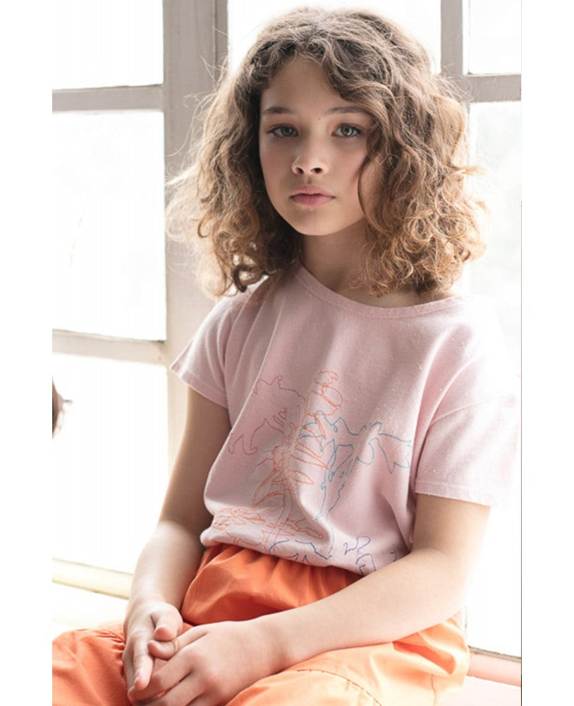 menina com t-shirt rosa com desenhos coloridos feitos com linha, saia laranja