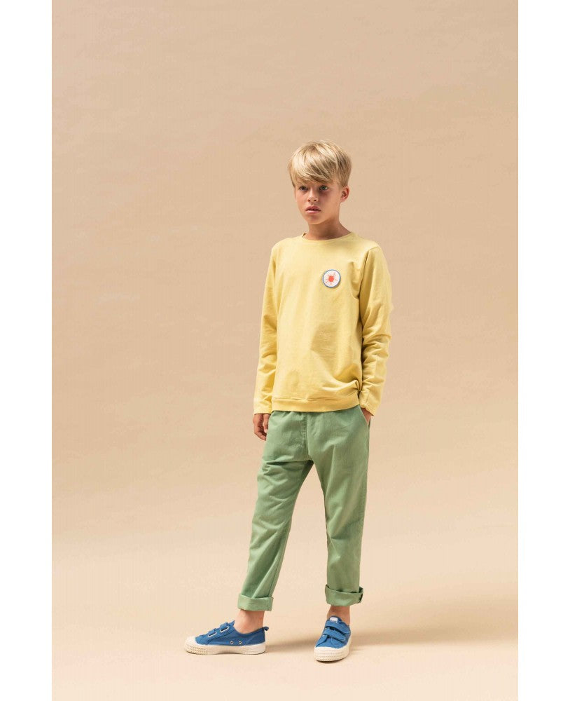 rapaz com calças verdes com elástico na cintura, sweat amarela